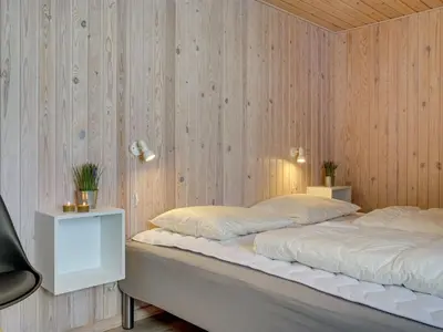 a bed in a room with a wooden wall at Holiday Home Afke - 900m from the sea by Interhome in Torsted
