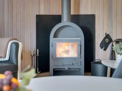 a fireplace in a living room with a stove at Holiday Home Afke - 900m from the sea by Interhome in Torsted