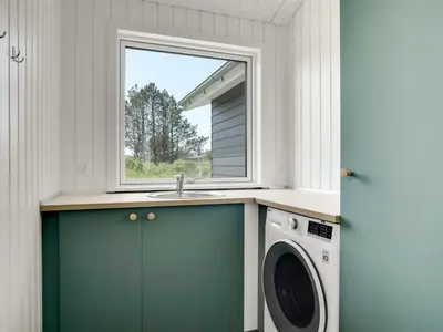 a laundry room with a sink and a washing machine at Holiday Home Raakel - 950m from the sea by Interhome in Torsted