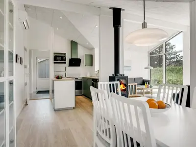 a kitchen and living room with a table and chairs at Holiday Home Raakel - 950m from the sea by Interhome in Torsted