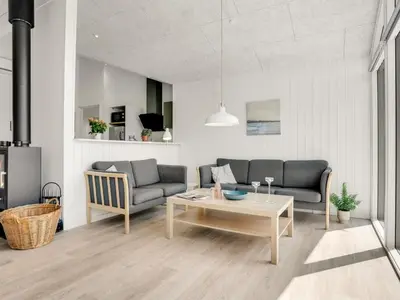 a living room with two couches and a table at Holiday Home Raakel - 950m from the sea by Interhome in Torsted