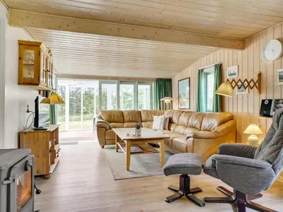 a living room with a couch and a table at Holiday Home Hughlek - 900m from the sea by Interhome in Torsted