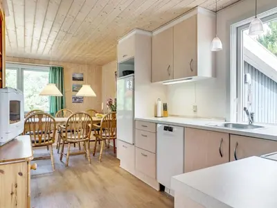 a kitchen and dining room with a table and chairs at Holiday Home Hughlek - 900m from the sea by Interhome in Torsted