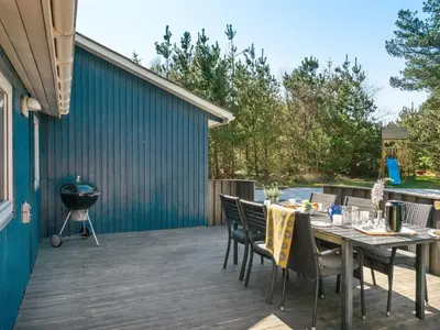 a deck with a table and chairs and a grill at Holiday Home Anegrete - 900m from the sea by Interhome in Torsted