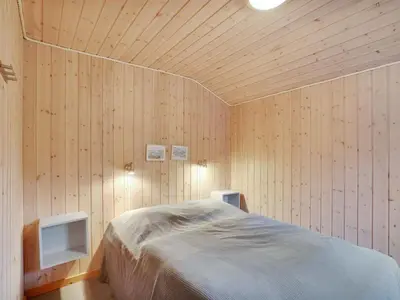 a bedroom with a bed in a room with wooden walls at Holiday Home Anegrete - 900m from the sea by Interhome in Torsted