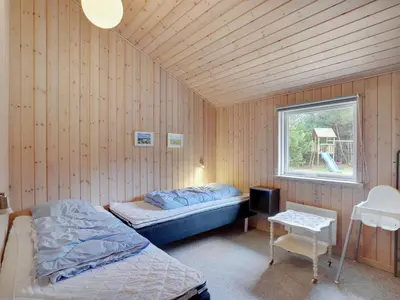a bedroom with two beds in a wooden wall at Holiday Home Anegrete - 900m from the sea by Interhome in Torsted