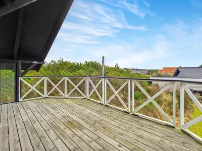 a wooden deck with a view of a field at Holiday Home Viktorija - 800m from the sea by Interhome in Torsted