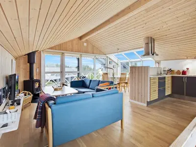 a living room with a blue couch and a table at Holiday Home Viktorija - 800m from the sea by Interhome in Torsted