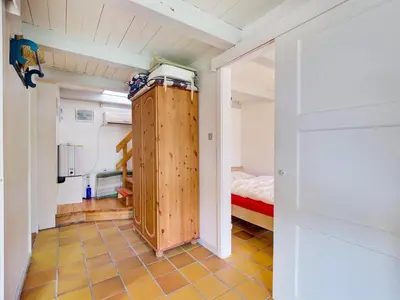 a small room with a bed and a wooden cabinet at Holiday Home Viktorija - 800m from the sea by Interhome in Torsted