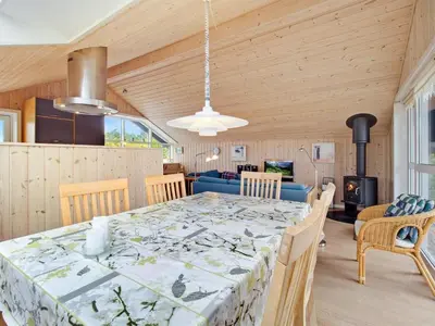 a dining room with a table and a couch at Holiday Home Viktorija - 800m from the sea by Interhome in Torsted