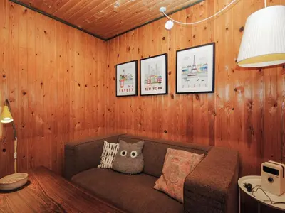 a living room with a couch in a wooden wall at Holiday Home Tuovi - 800m from the sea by Interhome in Torsted