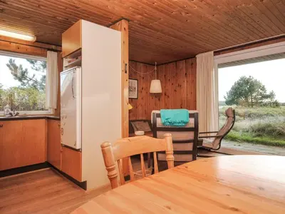 a kitchen and dining room with a table and chairs at Holiday Home Tuovi - 800m from the sea by Interhome in Torsted