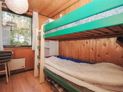 a bedroom with two bunk beds and a window at Holiday Home Tuovi - 800m from the sea by Interhome in Torsted