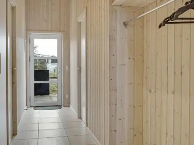 a hallway with wood paneled walls and a door at Holiday Home Mavis - 800m from the sea by Interhome in Torsted