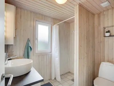a bathroom with a white sink and a toilet at Holiday Home Asmir - 1-1km from the sea by Interhome in Torsted