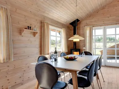a dining room with wooden walls and a table and chairs at Holiday Home Eggerich - 900m from the sea by Interhome in Torsted