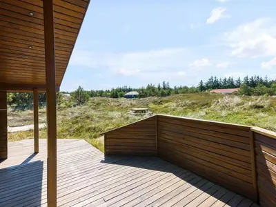 a wooden deck with a view of a field at Holiday Home Eggerich - 900m from the sea by Interhome in Torsted
