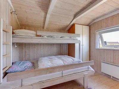 a room with two bunk beds and a window at Holiday Home Rink - 150m from the sea by Interhome in Torsted
