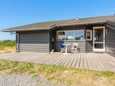 a house with a wooden deck in front of it at Holiday Home Rink - 150m from the sea by Interhome in Torsted