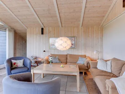a living room with a couch and a table at Holiday Home Rink - 150m from the sea by Interhome in Torsted