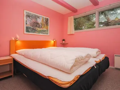 a bedroom with pink walls and a large bed at Holiday Home Amber - 500m from the sea by Interhome in Torsted