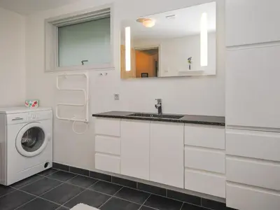 a white kitchen with a sink and a washing machine at Holiday Home Amber - 500m from the sea by Interhome in Torsted