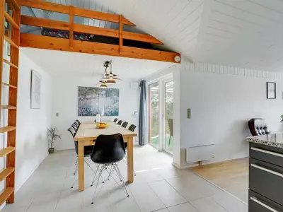 a kitchen and dining room with a wooden table and chairs at Holiday Home Germund - 900m from the sea by Interhome in Torsted