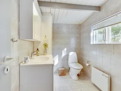 a white bathroom with a toilet and a sink at Holiday Home Pilvi - from the sea by Interhome in Torsted