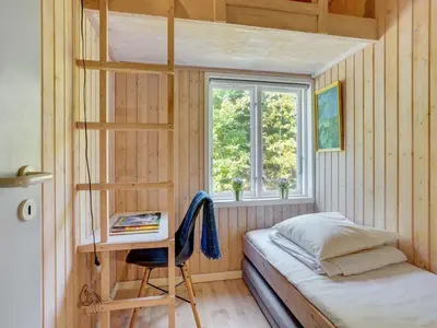 a bedroom with a bunk bed and a desk at Holiday Home Pilvi - from the sea by Interhome in Torsted