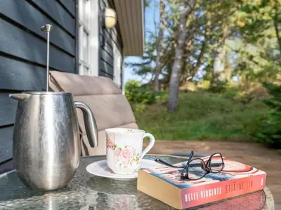 a book sitting on a table with a cup and a mug at Holiday Home Pilvi - from the sea by Interhome in Torsted