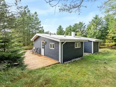 a tiny house with a deck in a field at Holiday Home Pilvi - from the sea by Interhome in Torsted
