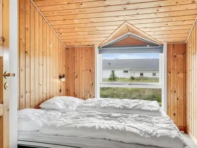 a large bed in a room with a window at Holiday Home Luzy - 600m from the sea by Interhome in Torsted