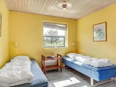 two beds in a room with a window at Holiday Home Bodulf - 600m from the sea by Interhome in Torsted