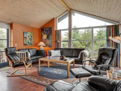 a living room with black leather furniture and windows at Holiday Home Bodulf - 600m from the sea by Interhome in Torsted