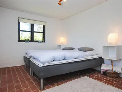 a bedroom with a large bed in a room at Holiday Home Duco - 300m from the sea by Interhome in Torsted
