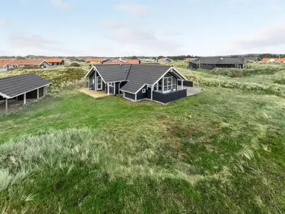 a house on the beach with a grass field at Holiday Home Thyrger - 550m from the sea by Interhome in Torsted