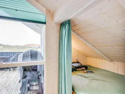 a bed in a tiny house with a window at Holiday Home Thyrger - 550m from the sea by Interhome in Torsted