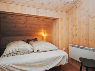 a bedroom with a bed in a wooden wall at Holiday Home Laurentia - 800m from the sea by Interhome in Torsted