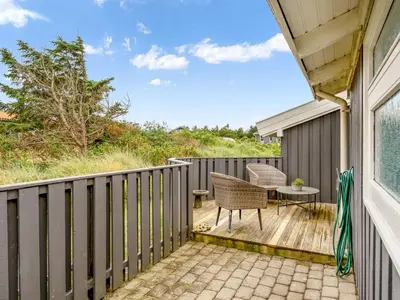 a patio with a table and chairs on a deck at Holiday Home Laurentius - 300m from the sea by Interhome in Torsted