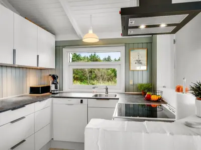 a kitchen with white cabinets and a window at Holiday Home Laurentius - 300m from the sea by Interhome in Torsted