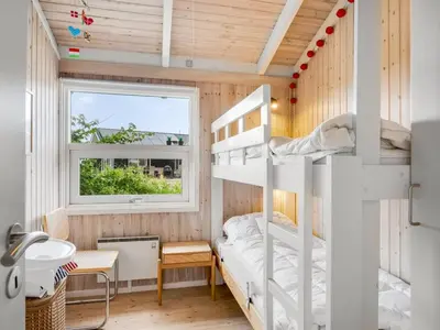 a bunk bed in a room with a window at Holiday Home Laurentius - 300m from the sea by Interhome in Torsted