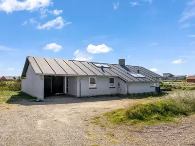a white house with a gambrel roof on a field at Holiday Home Hornbogi - 300m from the sea by Interhome in Torsted