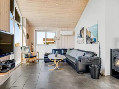 a living room with a couch and a table at Holiday Home Hornbogi - 300m from the sea by Interhome in Torsted