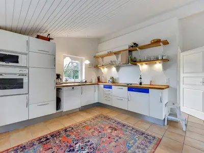 a kitchen with white cabinets and a rug on the floor at Holiday Home Vivina - 250m from the sea by Interhome in Torsted