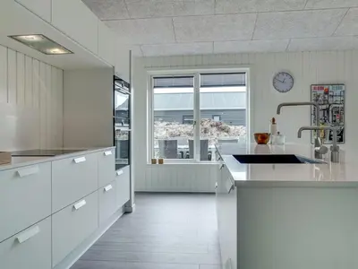 a kitchen with white cabinets and a large window at Holiday Home Helli - 650m from the sea by Interhome in Torsted