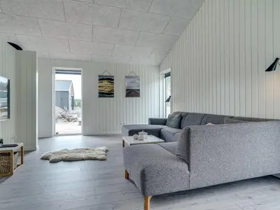 a living room with a couch and a table at Holiday Home Helli - 650m from the sea by Interhome in Torsted
