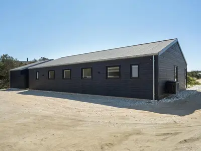 a black building sitting on top of a dirt field at Holiday Home Helli - 650m from the sea by Interhome in Torsted