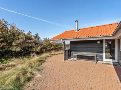 a house with a bench on a brick driveway at Holiday Home Øde - 350m from the sea by Interhome in Torsted