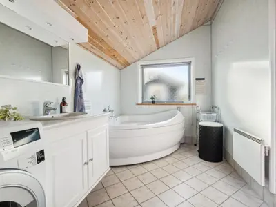 a white bathroom with a tub and a sink at Holiday Home Øde - 350m from the sea by Interhome in Torsted