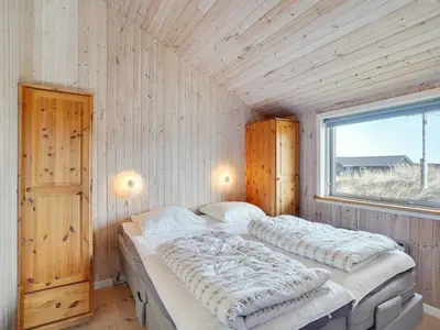 two beds in a room with a window at Holiday Home Øde - 350m from the sea by Interhome in Torsted